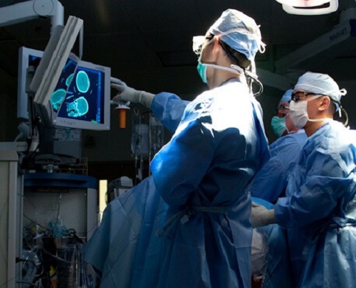 doctors in ER room pointing at computer screen